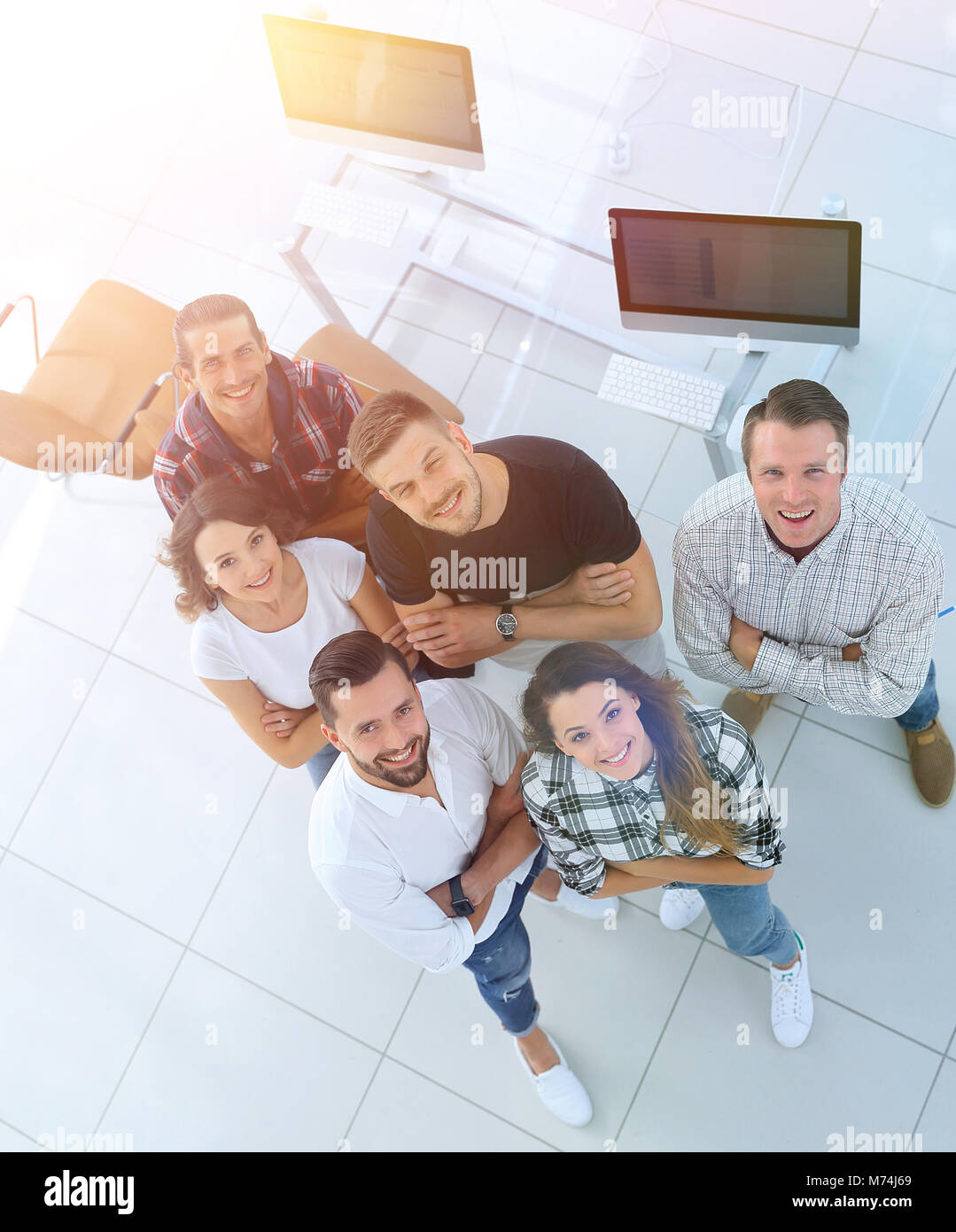 young professionals standing near the desktop Stock Photo - Alamy