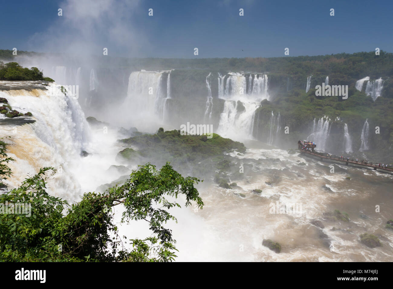 Aerial panorama Iguazu Falls waterfalls with perspective, tourists in mist on walkway, UNESCO world heritage site, natural wonders of the world Stock Photo