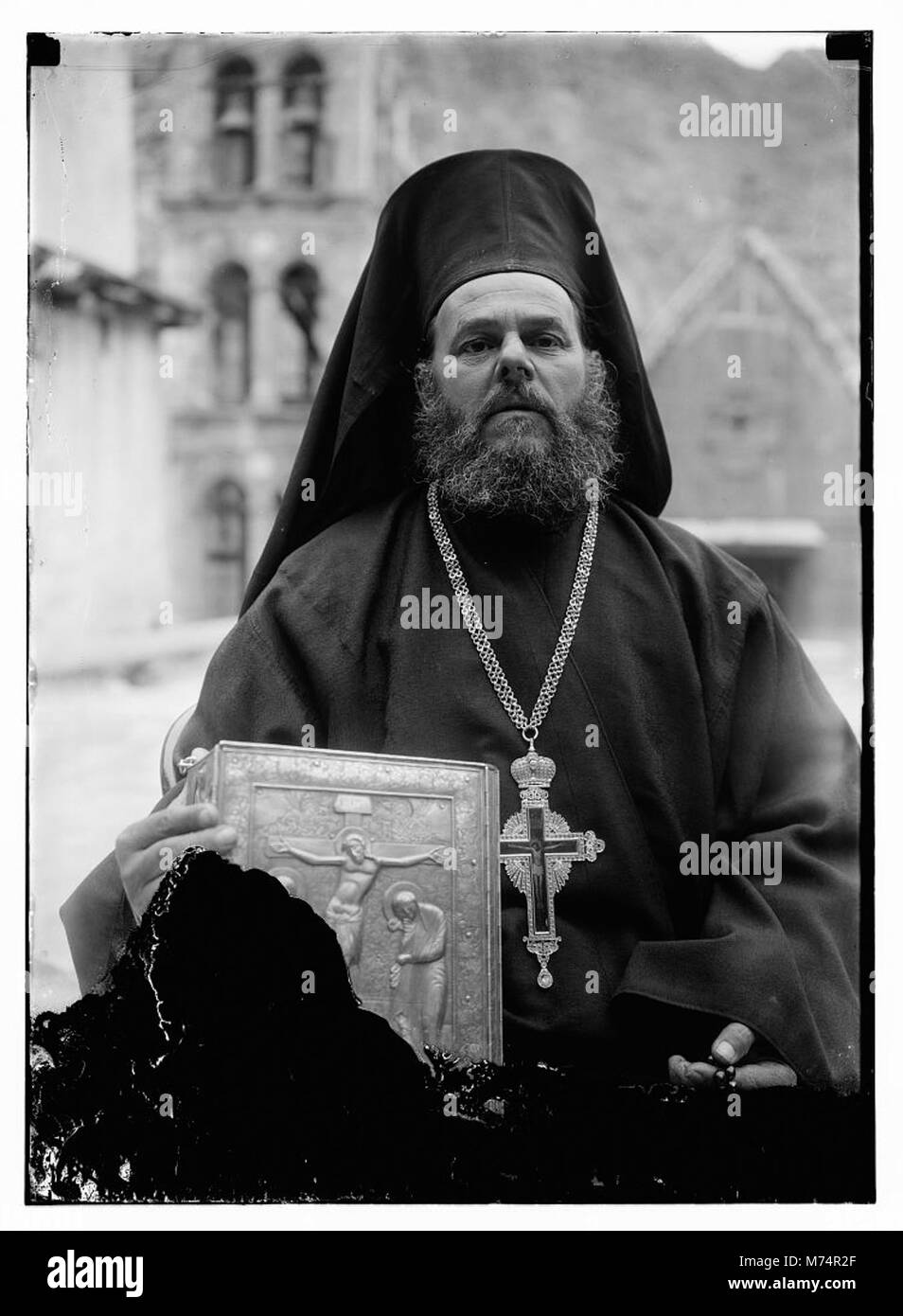 Greek Orthodox priest at St. Catherine's Monastery in the Sinai holding prized manuscript with silver cover from their library LOC matpc.09657 Stock Photo