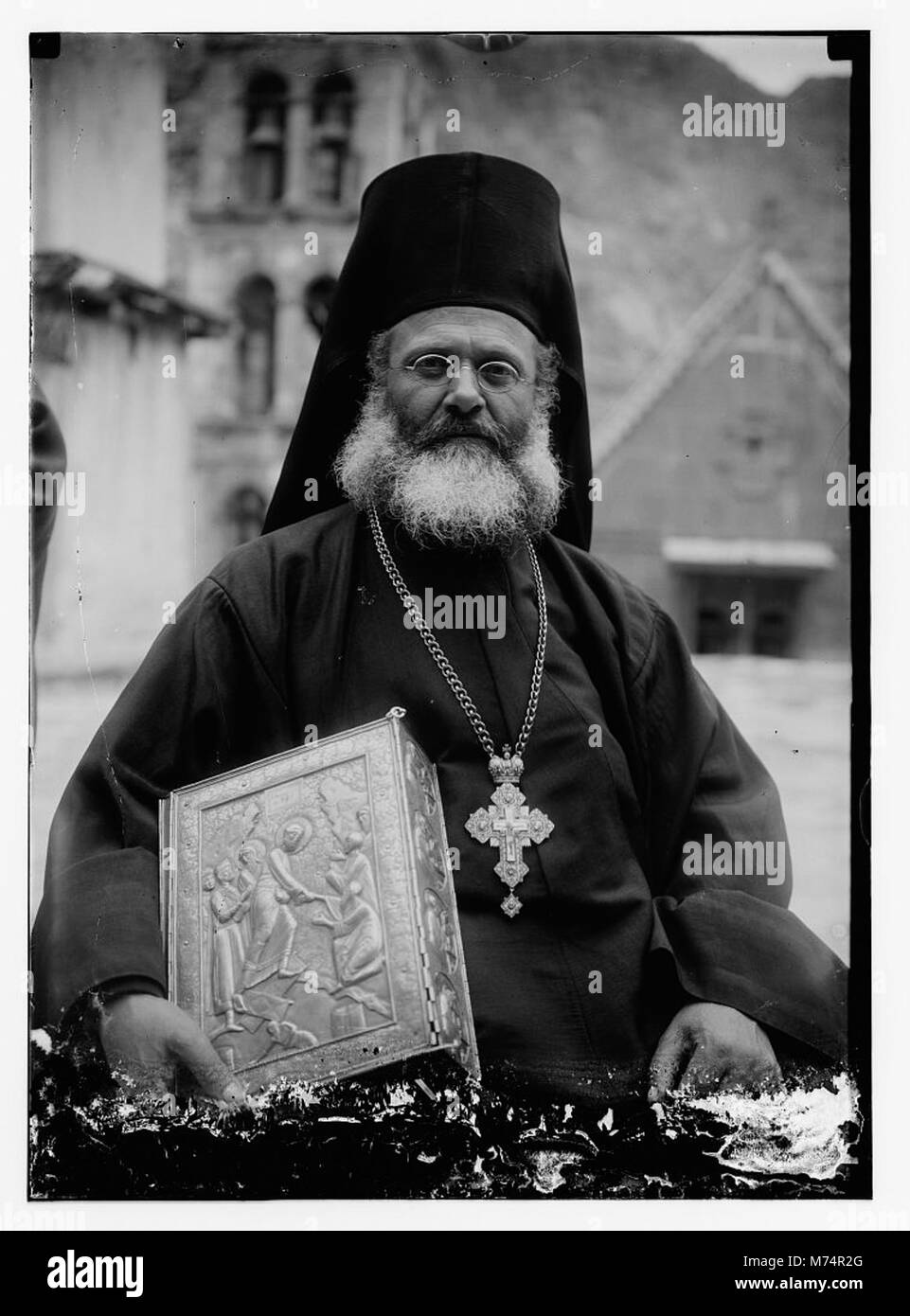 Greek Orthodox priest at St. Catherine's Monastery in the Sinai holding prized manuscript with silver cover from their library LOC matpc.09662 Stock Photo
