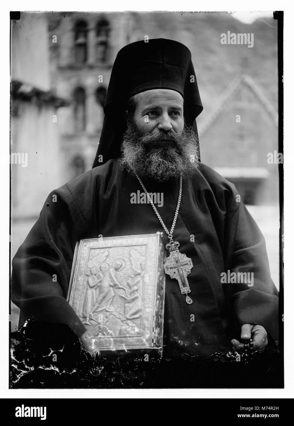 Greek Orthodox priest at St. Catherine's Monastery in the Sinai holding prized manuscript with silver cover from their library LOC matpc.09663 Stock Photo