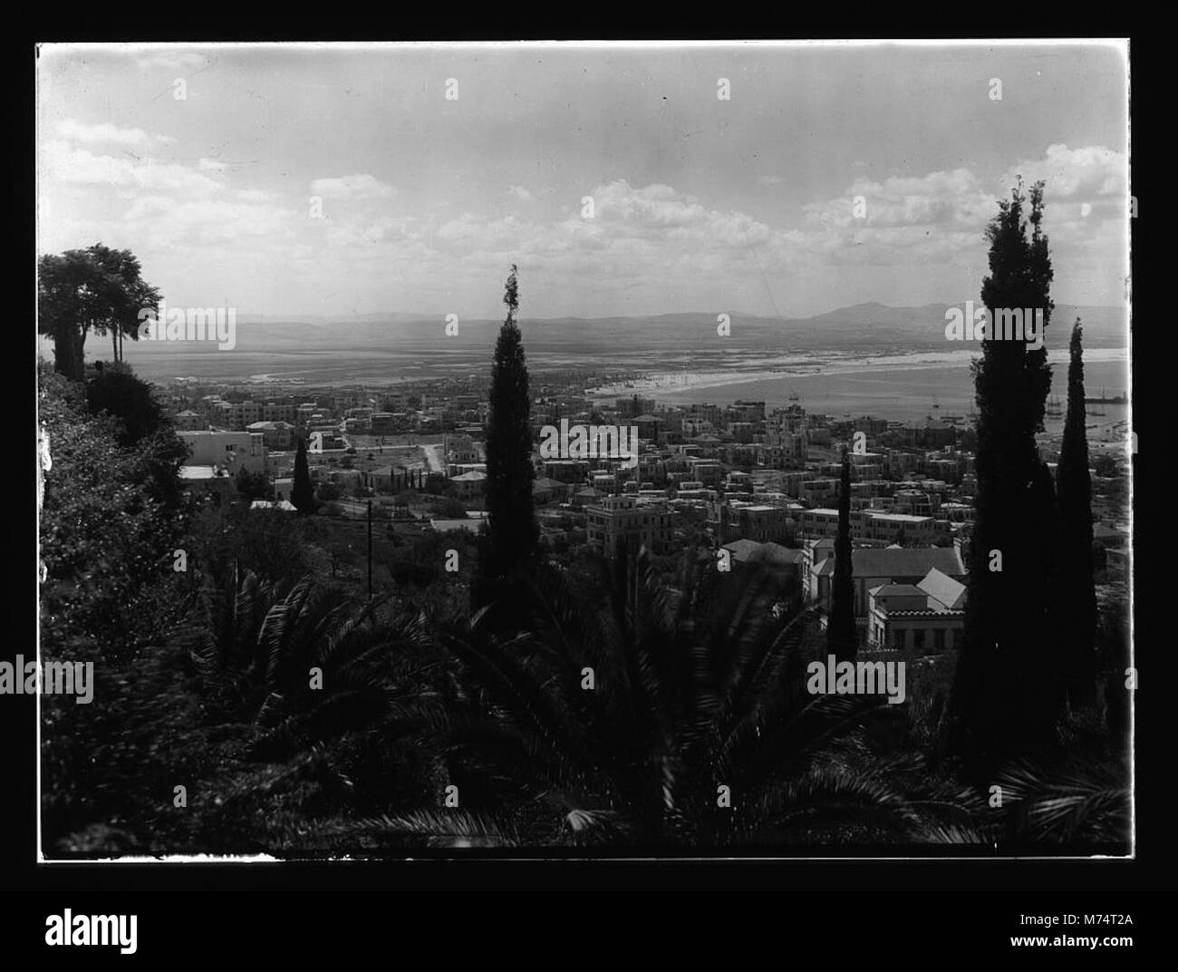 A panoramic view of Haifa from Mount Carmel, showcasing the city and its coastline. The photograph captures the natural beauty of the region, with its Mediterranean climate and the surrounding landscape. Stock Photo