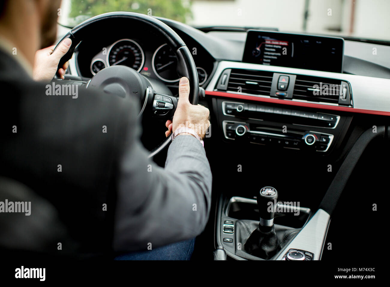 Back view of an handsome smiling business man driving his car Stock ...