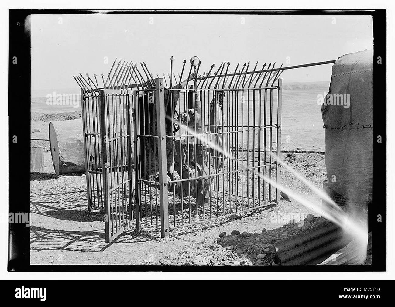 A photograph showing men in a cage at Gayara bitumen, Iraq, which ...