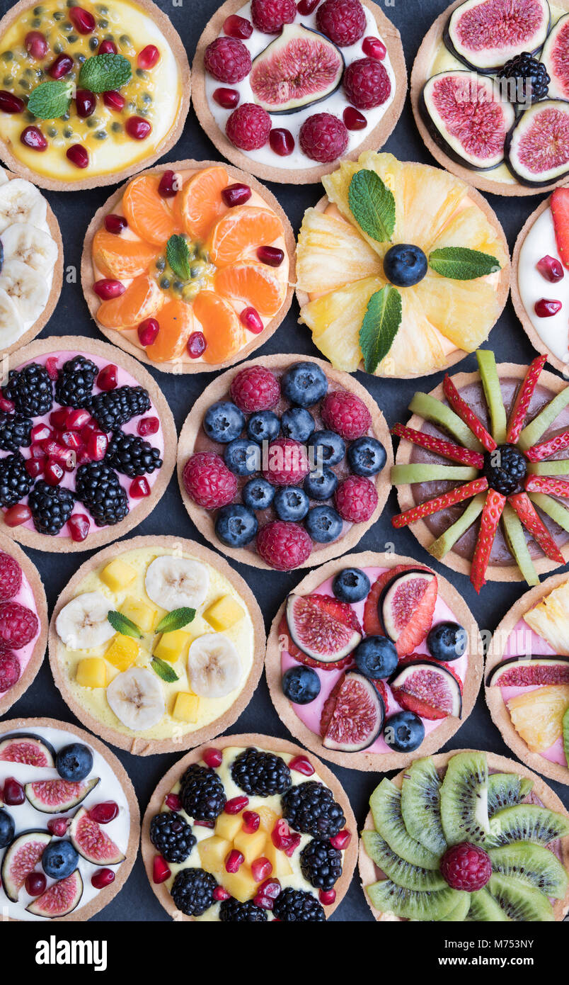 Colourful fruit tarts on a slate background Stock Photo