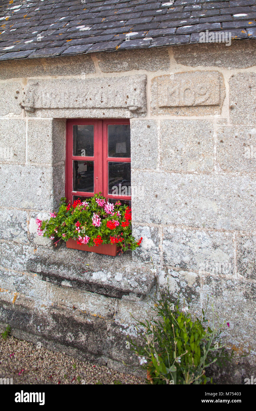 Red window with flowers on windowsill and old medieval decorative wall ...