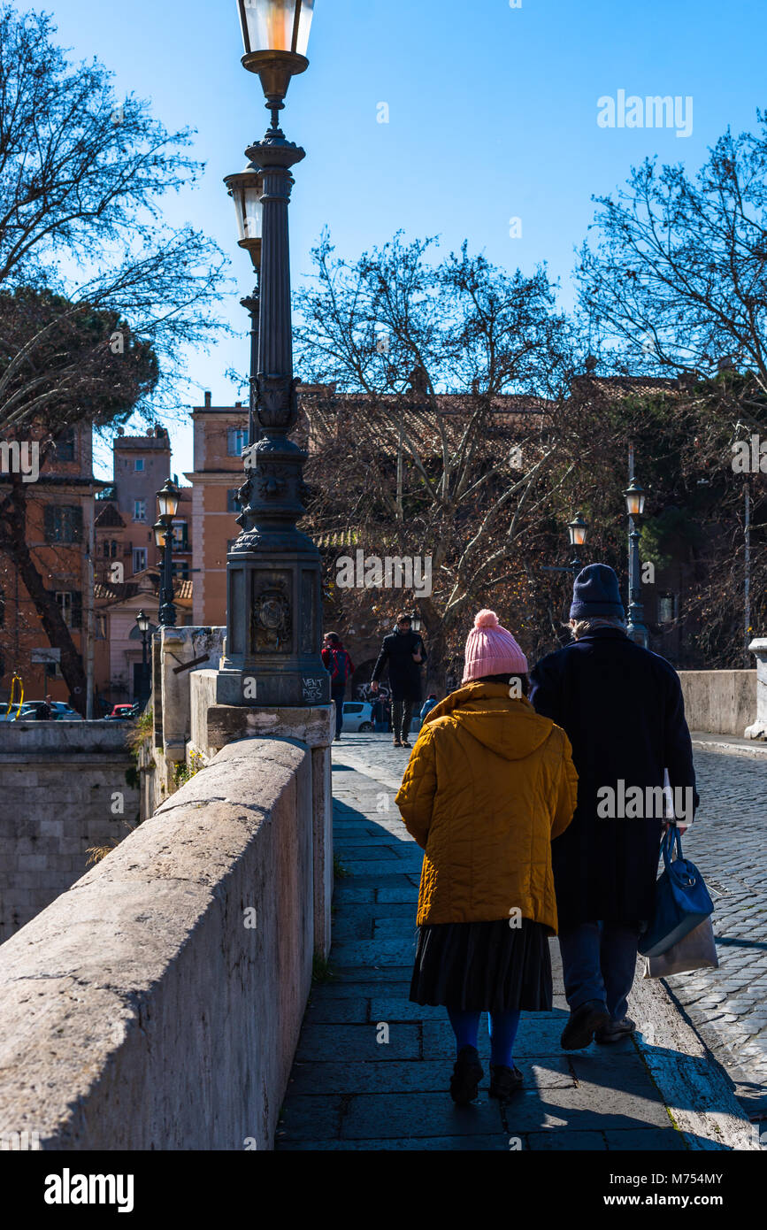 Old Italian couple crossing bridge from Tiber Island to Trastavere Stock Photo
