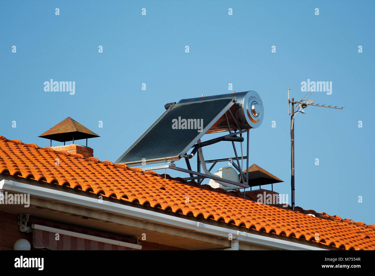 Solar panel for heating water and television antennas, in a roof of a house Stock Photo