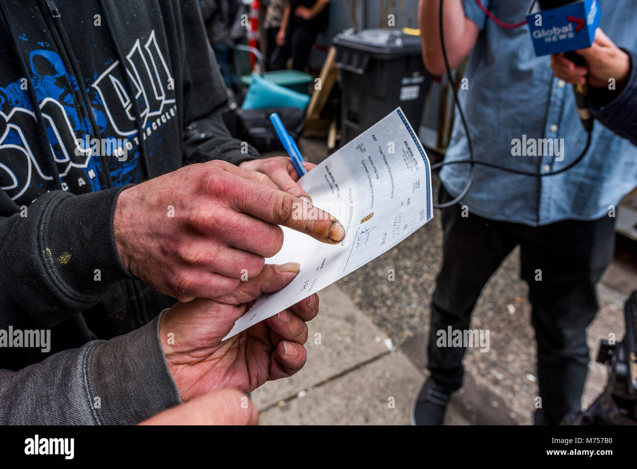 Man gets compensation cheque on Eviction Day, Balmoral Hotel, DTES, Vancouver, British Columbia, Canada. Stock Photo