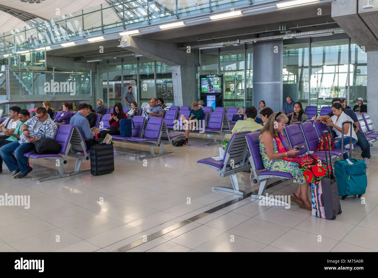 Passengers waiting at the gate to board plane, Suvarnabhumi airport, Bangkok, Thailand Stock Photo