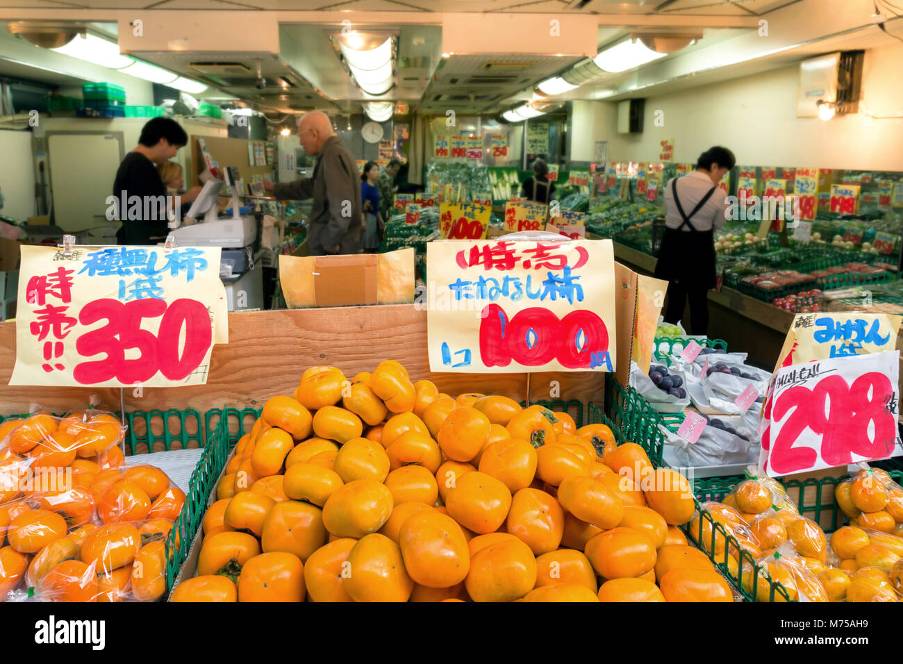 Tokyo, Japan - May 17, 2019 : fresh japanese fuyu persimmon selling in fruit and vegetable local greengrocer shop at the market in Tokyo, Japan. Stock Photo