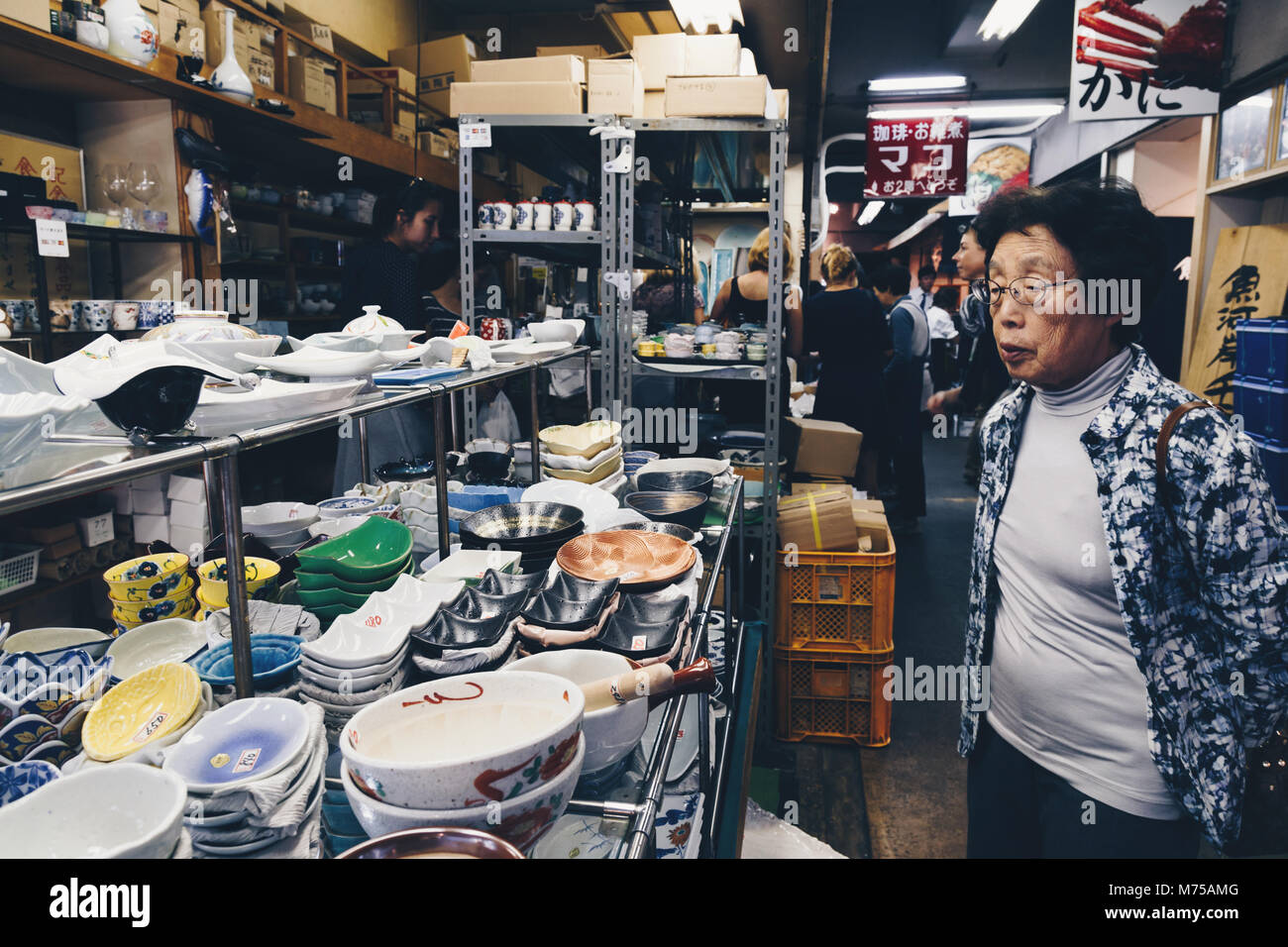 Tsukiji, Tokyo, Japan - January 24, 2018 : one senior japanese woman and many tourists are shopping ceramic dishware in traditional kitchenware shop a Stock Photo