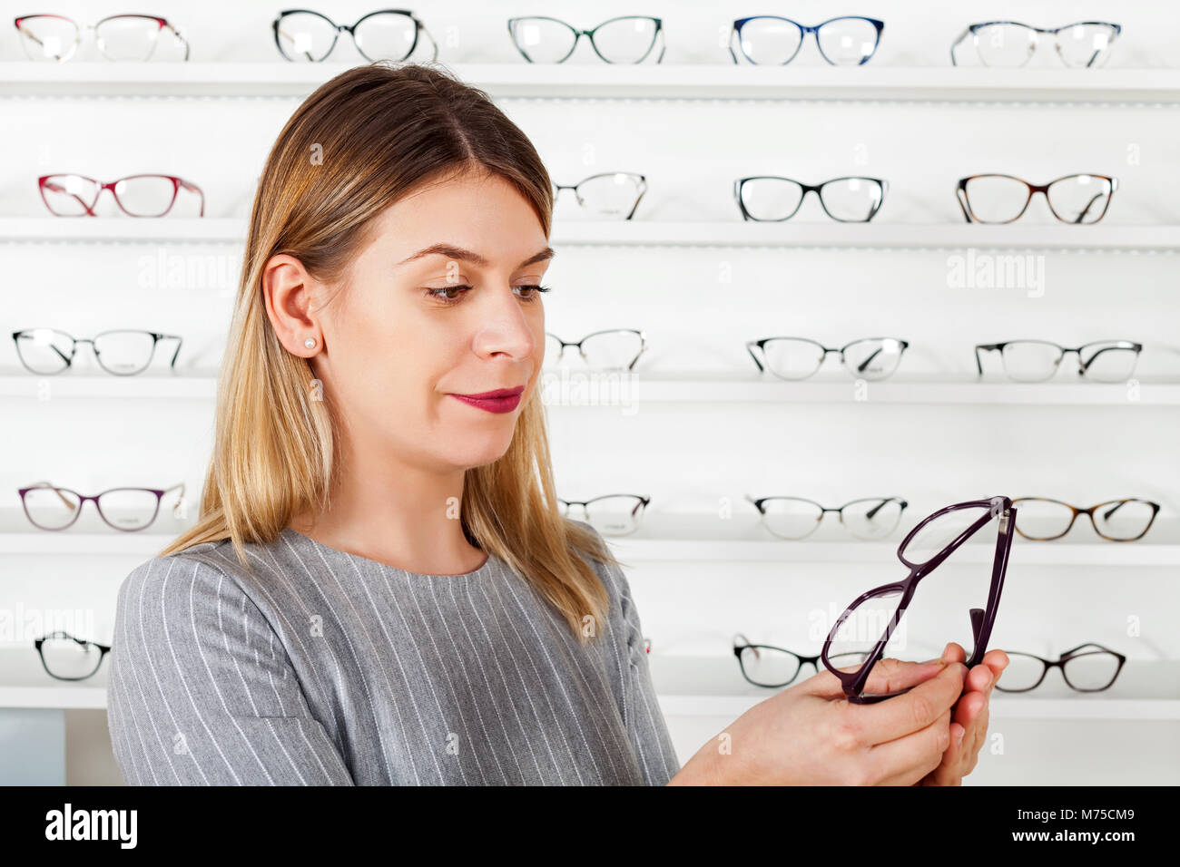Young woman in optical store choosing eyeglasses frames Stock Photo Alamy