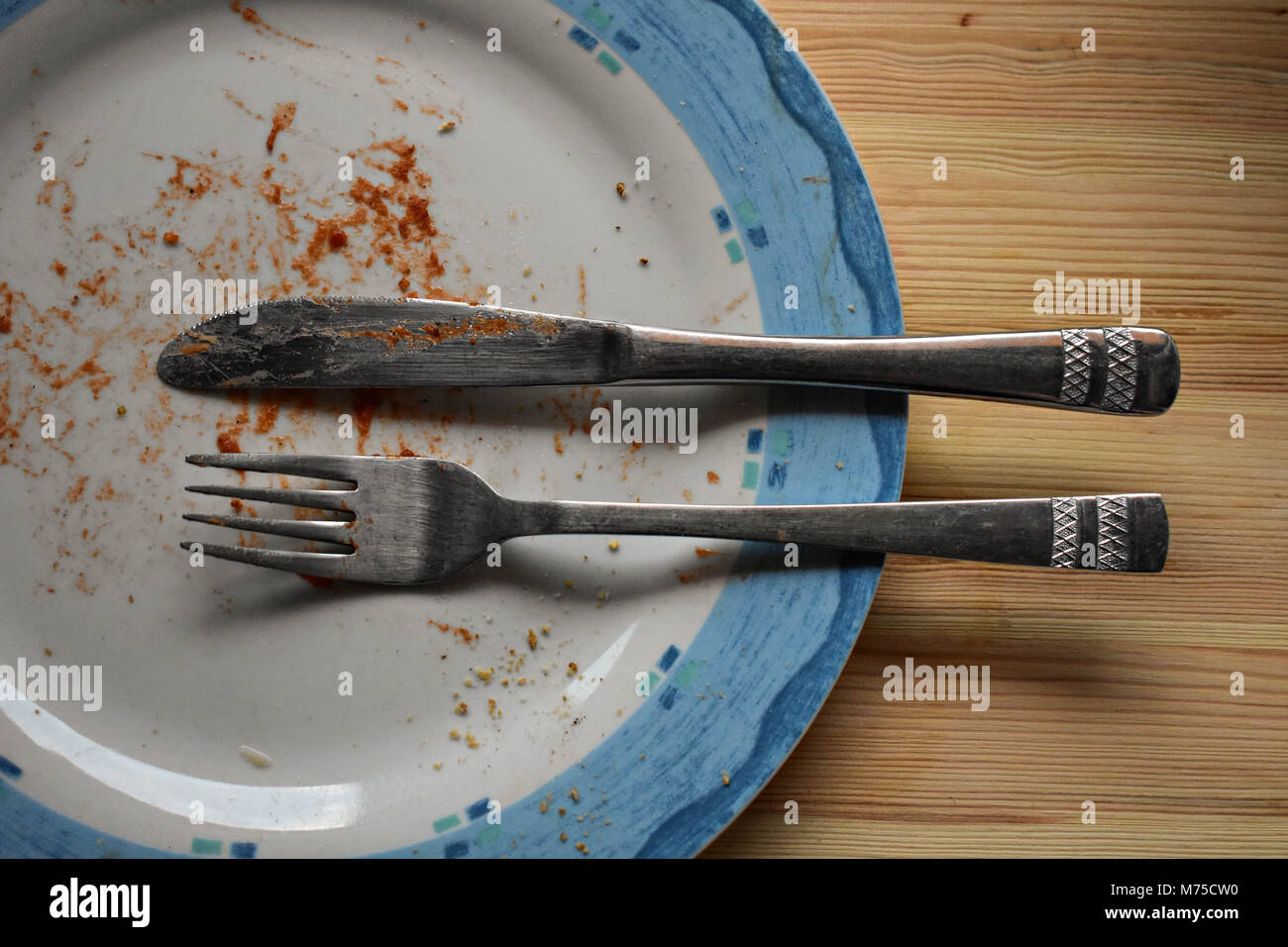 Empty Dirty plate after food on table with wooden background Stock