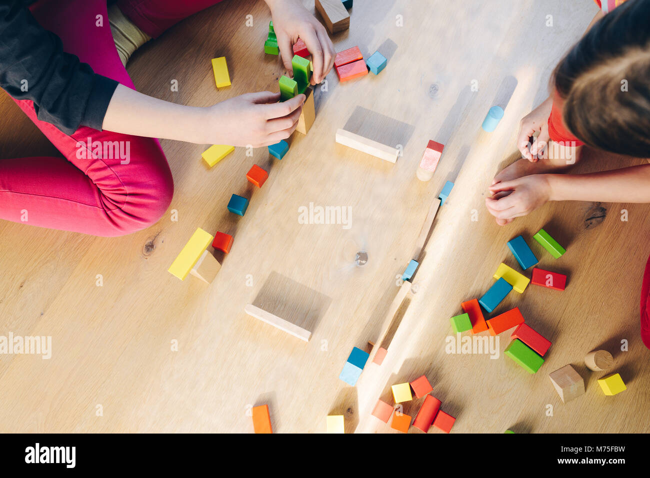 children playing with colorful wooden blocks - view from above Stock ...