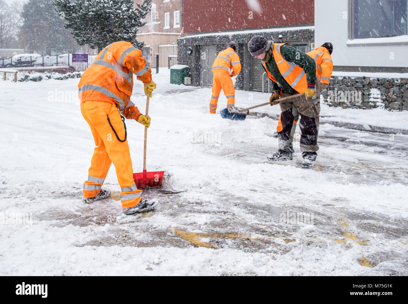 Workers clearing snow from a road into a car park, West Bridgford