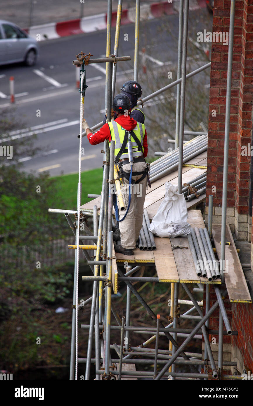 Workmen erecting scaffolding in Paisley Scotland Stock Photo