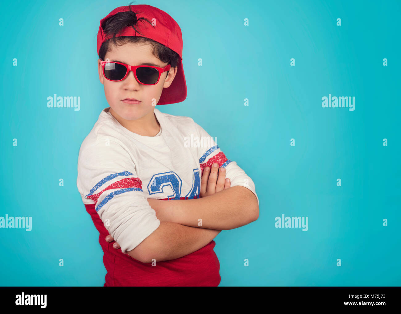 serious boy with sunglasses on blue background Stock Photo