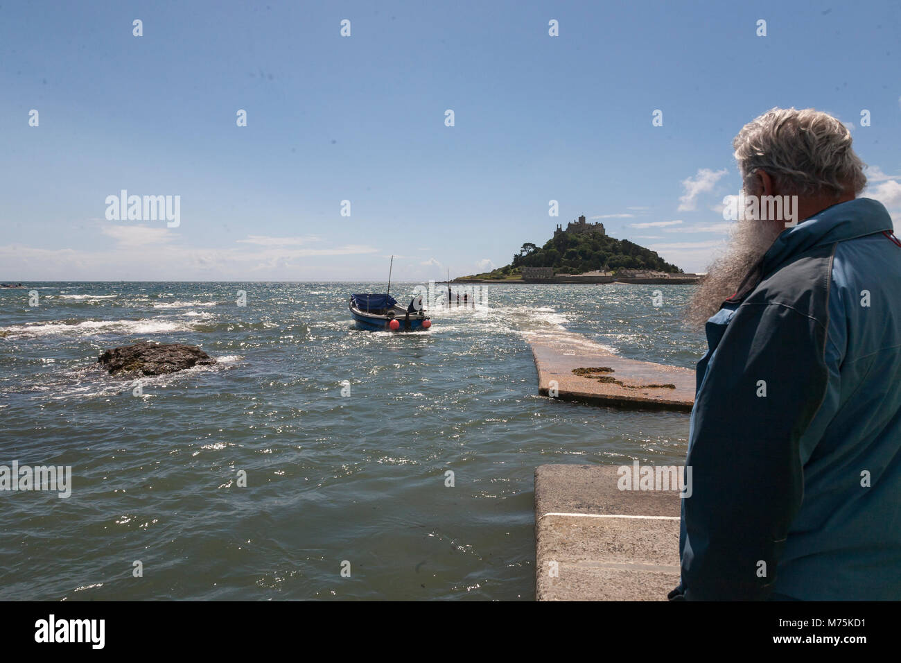 St Michaels Mount, England, July 21, 2010: An elderly man waiting for a boat taking tourist to St Michaels Mount in Cornwall. Stock Photo
