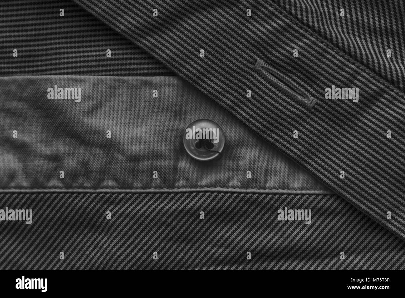 Close-up stripped fabric texture with button, monochrome background ...