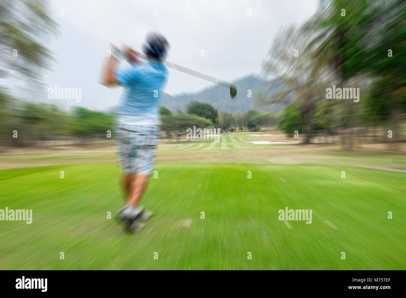 Motion blur golfer swinging driver club on teeing ground sending golf
