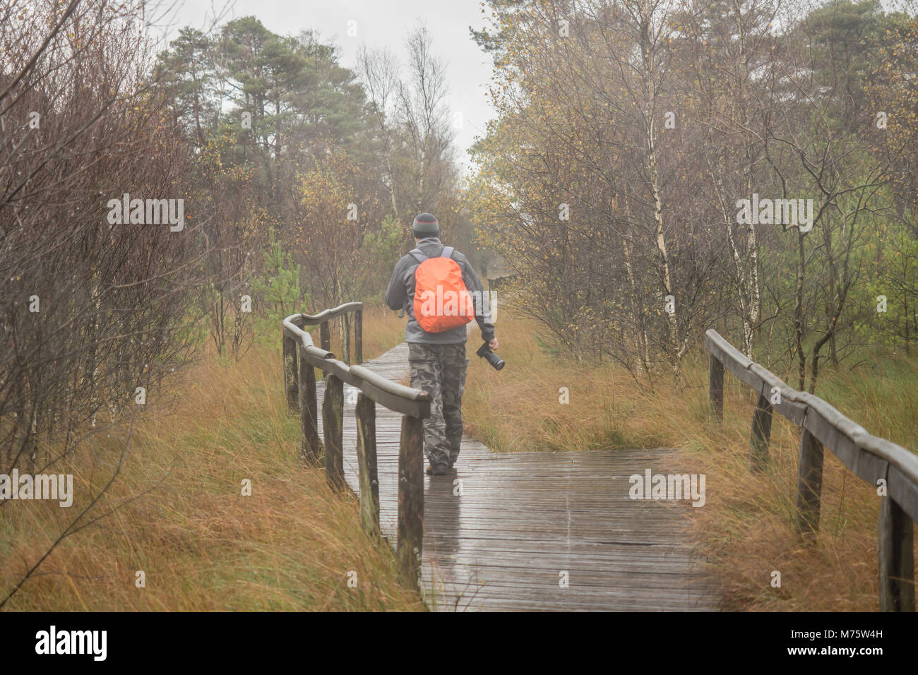 A photographer with a camera in the rain Stock Photo Alamy