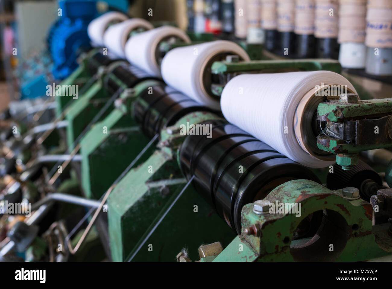 Spools with thread at rewinding machine view Stock Photo - Alamy