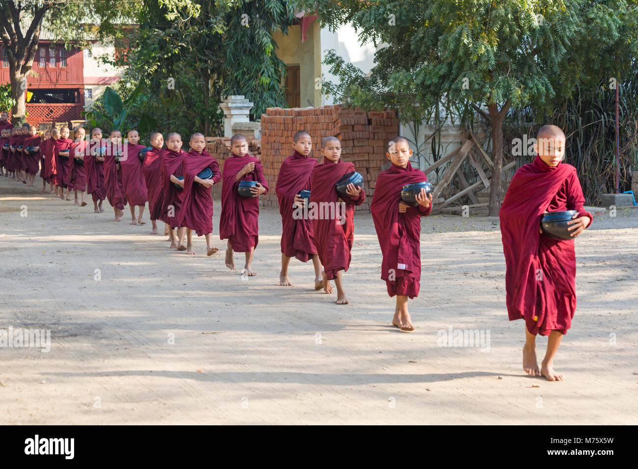 Procession of Buddhist monks collecting alms at Bagan, Myanmar (Burma), Asia in February Stock Photo