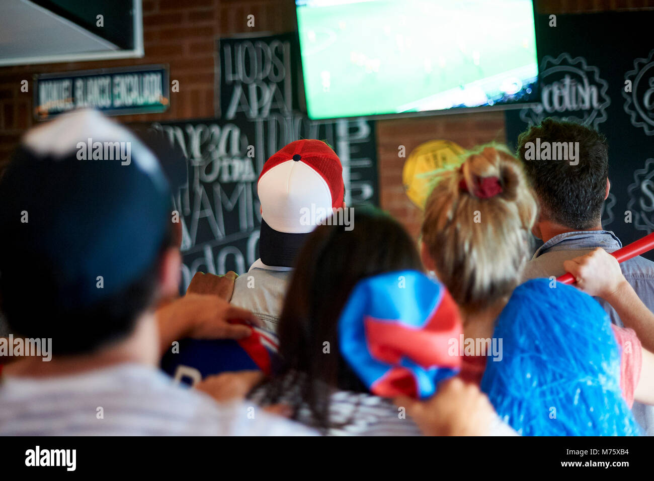 French football fans watching soccer match on television at pub Stock