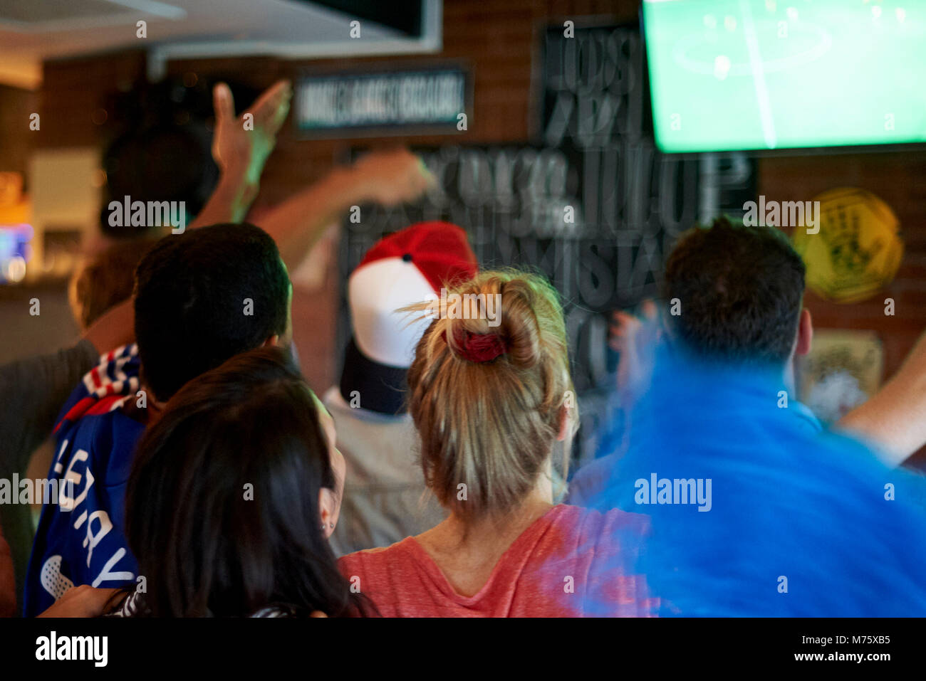 French football fans watching soccer match on television at pub Stock