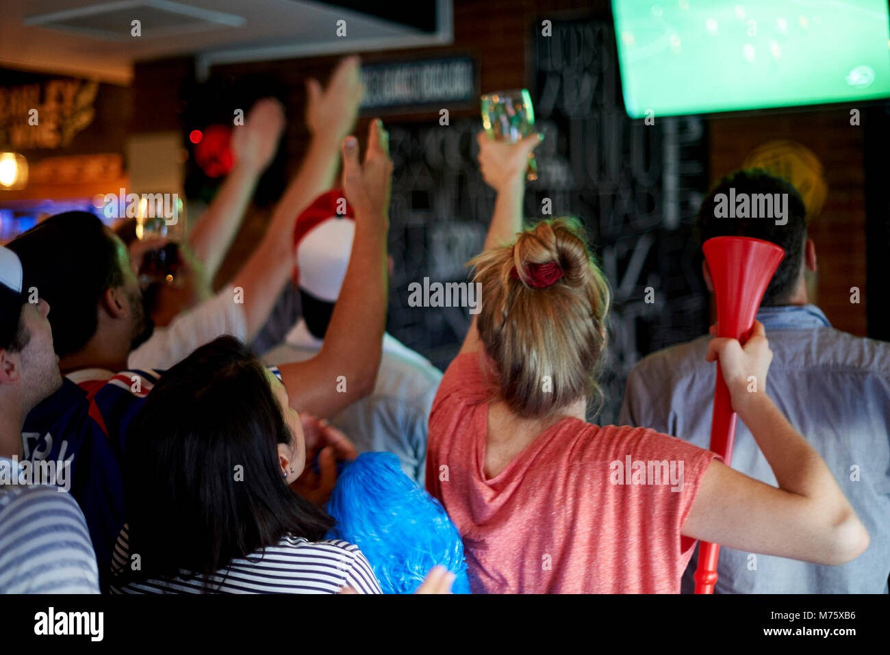 French football fans watching soccer match on television at pub Stock Photo