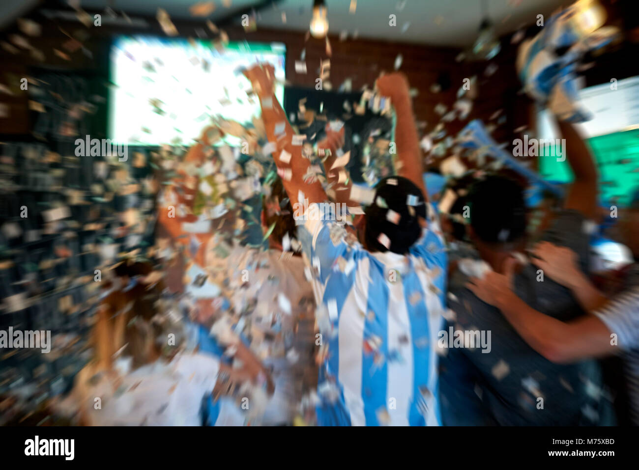 Argentinian football fans watching football match at sports bar Stock Photo