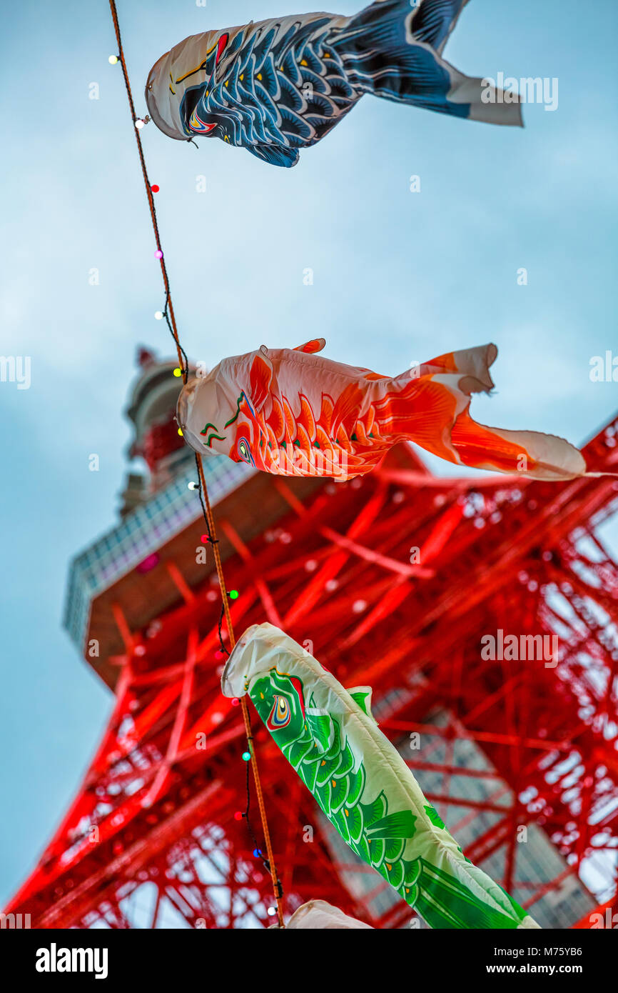 Tokyo, Japan - April 23, 2017: closeup of Koinobori a carp-shaped wind socks traditionally flown in Japan to celebrate Children's Day during Golden Week. Blurred Tokyo Tower on blue sky. Vertical shot Stock Photo