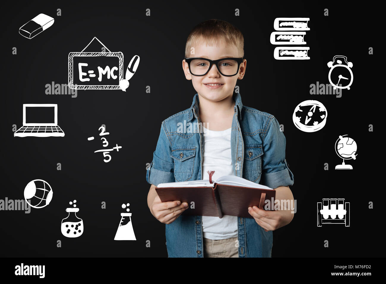 Smart boy in glasses wearing glasses and holding an important notebook