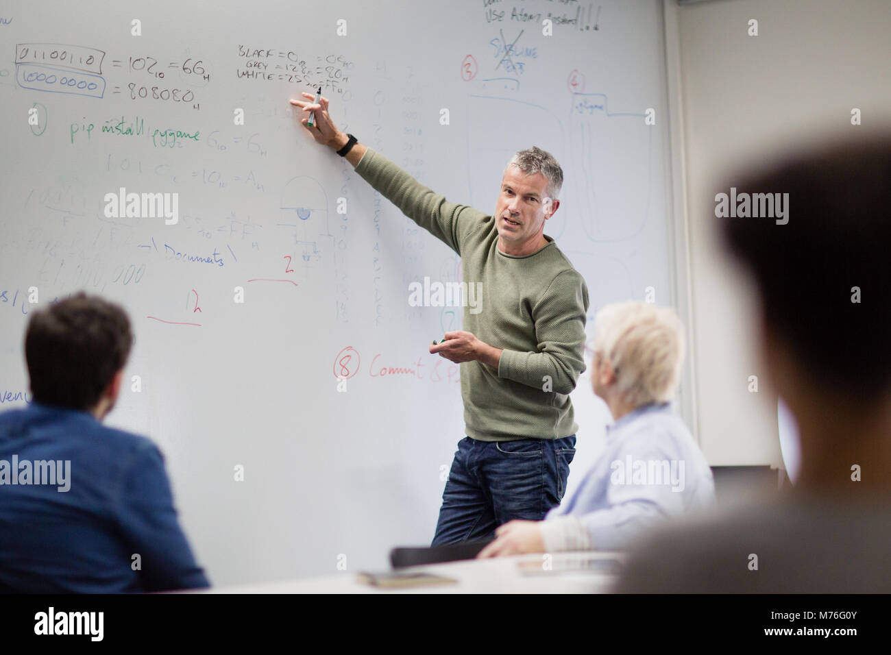 Teacher using white board in adult education course Stock Photo