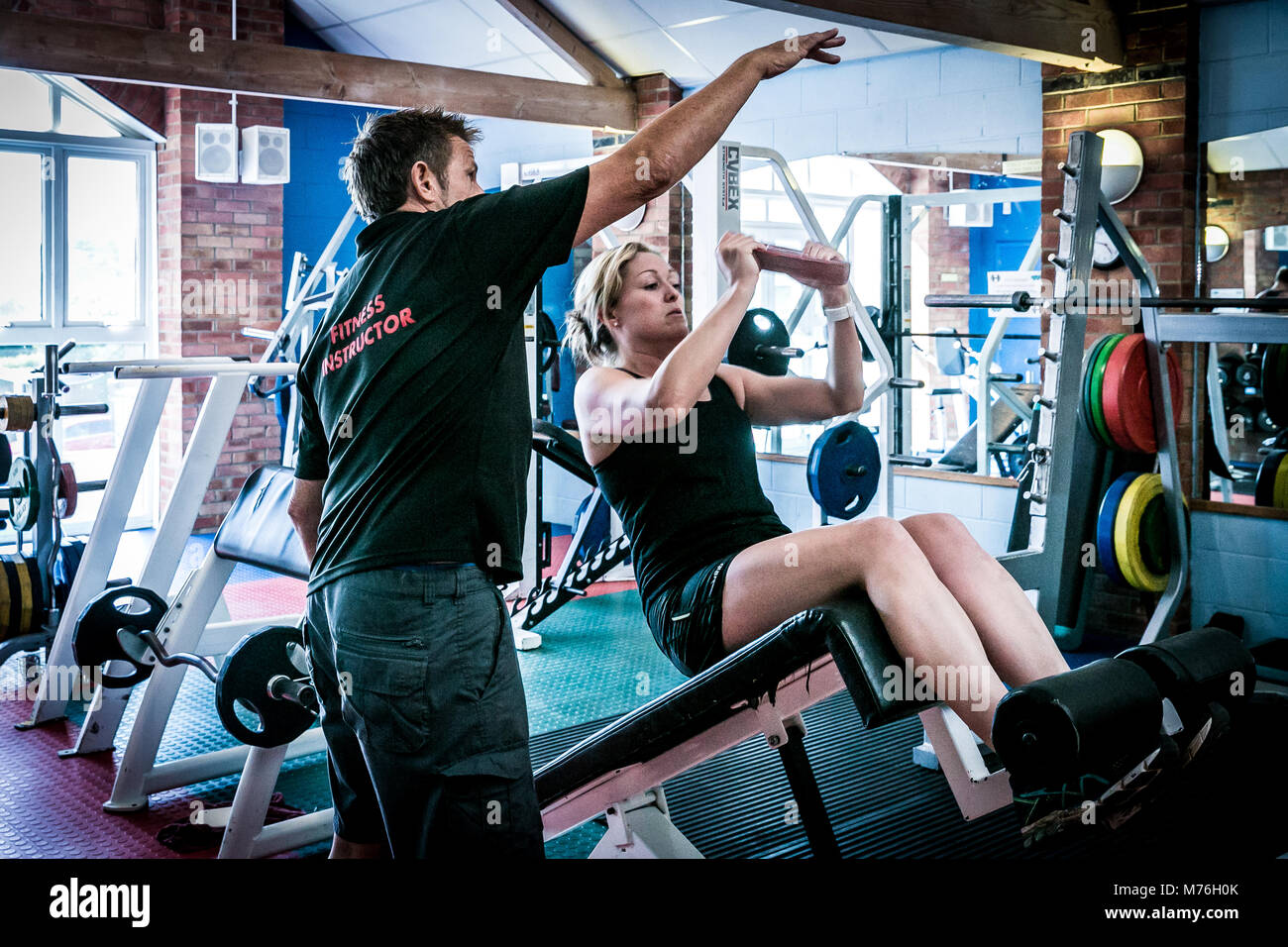 Woman receiving one to one training from male fitness instructor Stock Photo