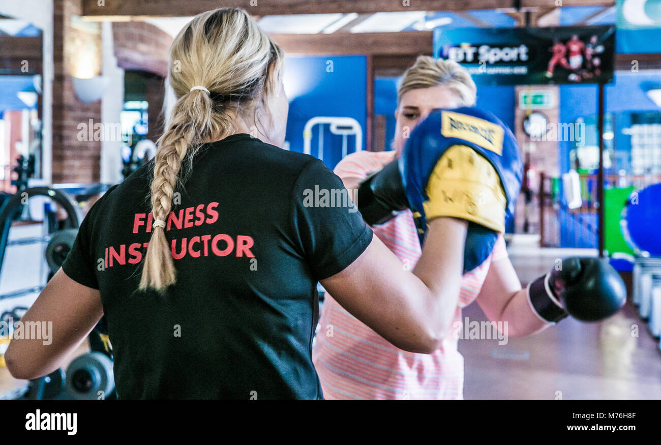 Female fitness instructor boxing with female client. in a one to one workout in the gym Stock Photo