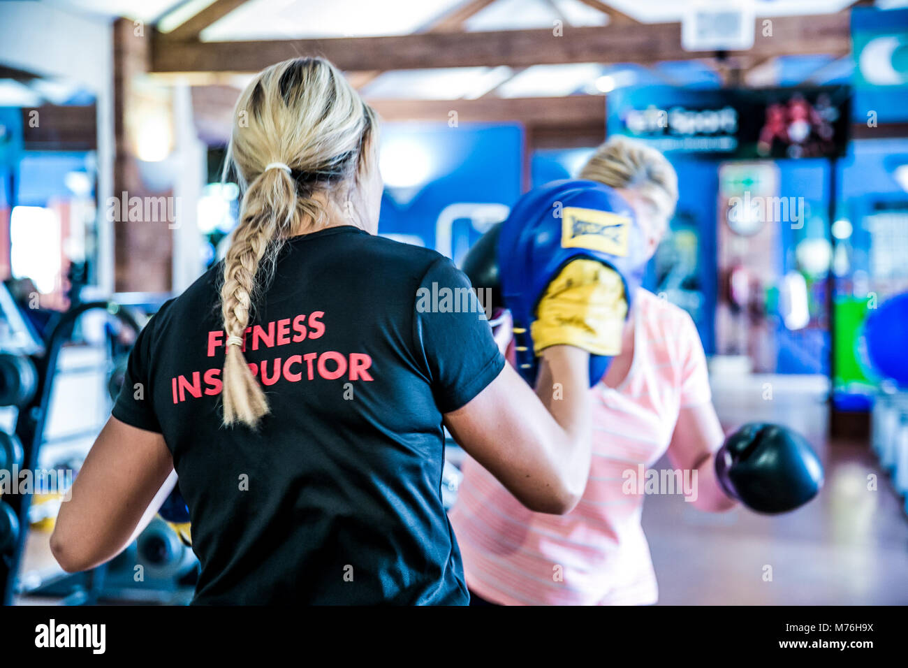 Female fitness instructor boxing with female client. in a one to one workout in the gym Stock Photo