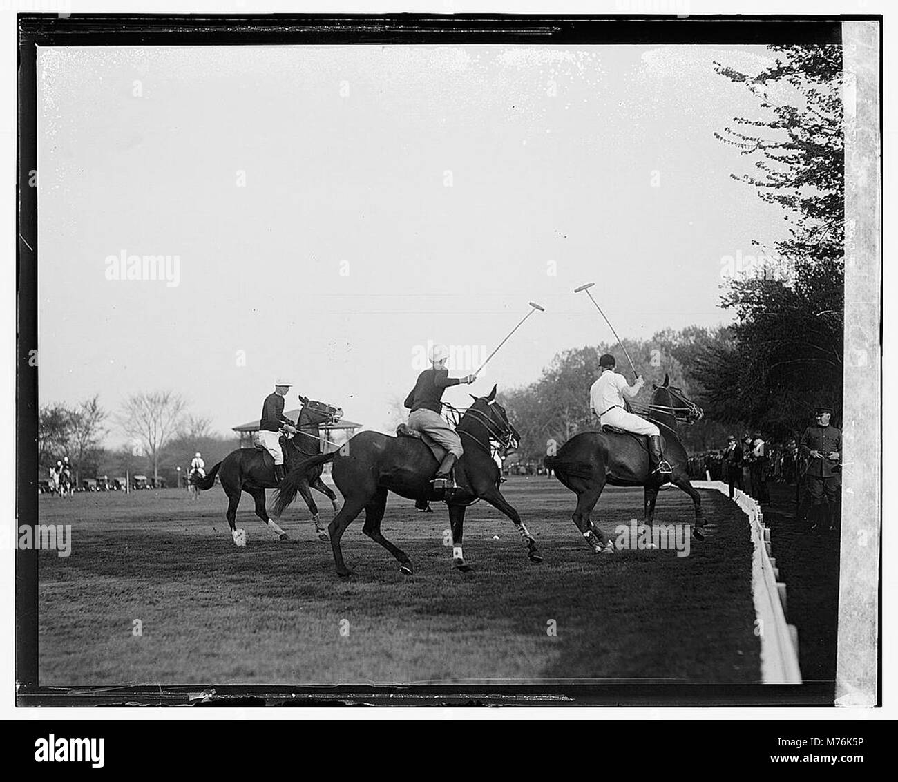 The photograph captures a scene from a polo match, a team sport played ...