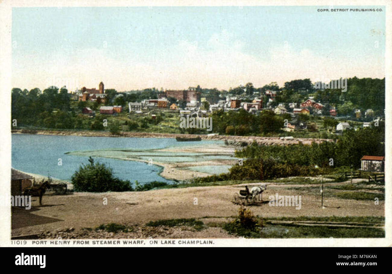 This photograph captures a scenic view of Port Henry from the Steamer Wharf on Lake Champlain. The image highlights the beautiful lakefront and surrounding area, offering a glimpse of the local harbor and surrounding landscape. Stock Photo