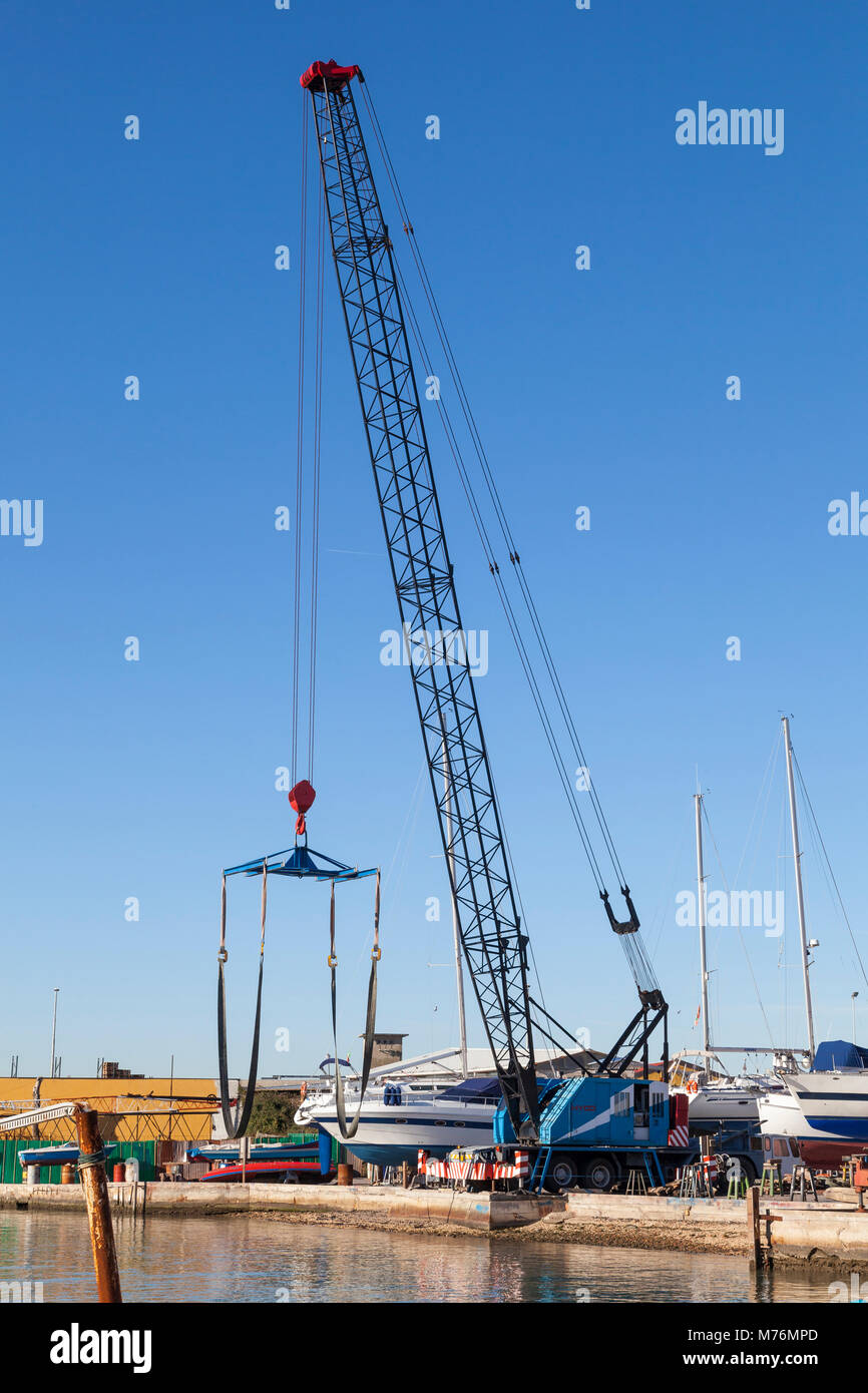 Large boat crane  or lift with a sling on the quay at the harbour In the fishing port of Chioggia, Venice, Veneto, Italy in the southern Venetian lago Stock Photo