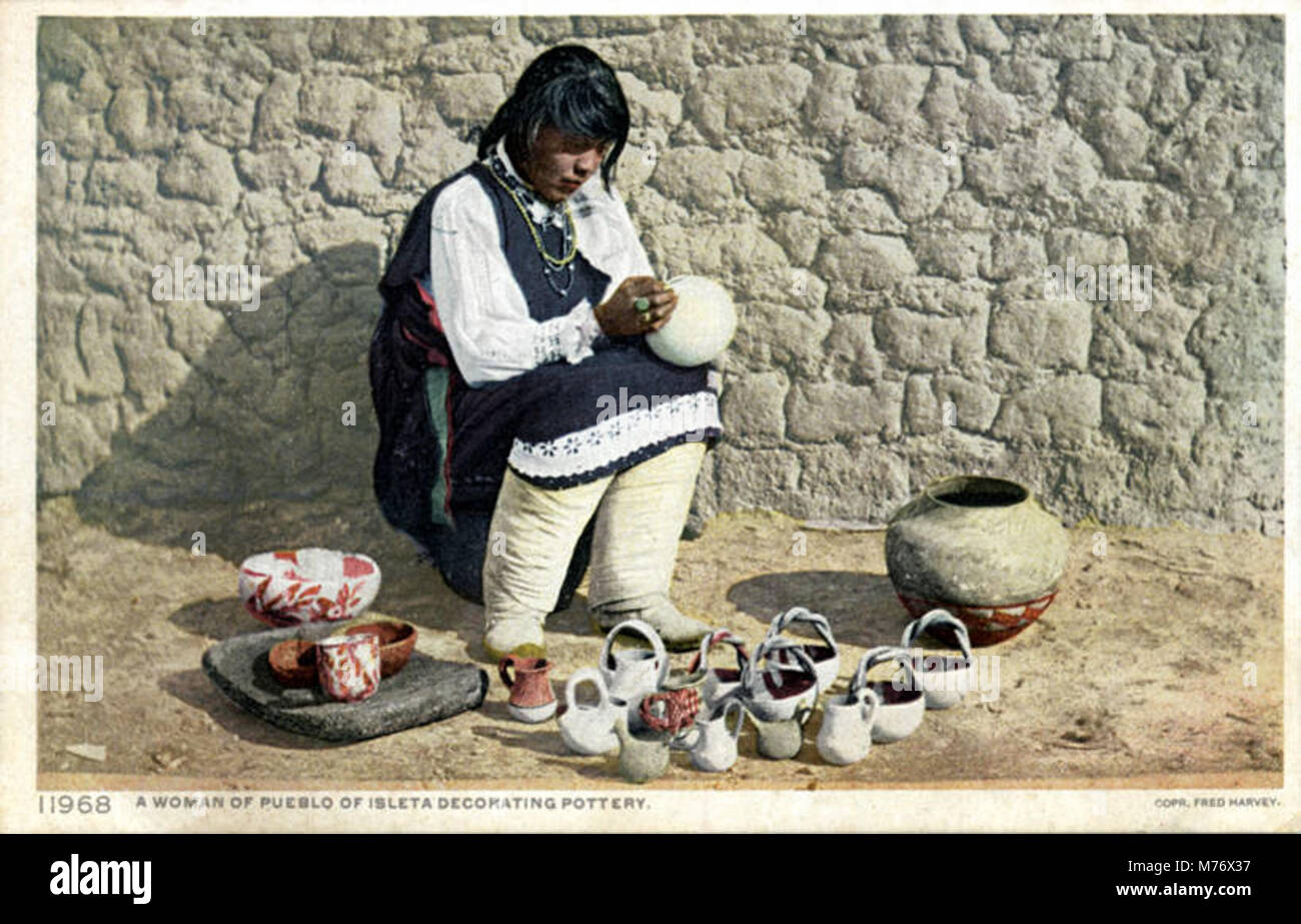 A photograph of a woman from the Pueblo of Isleta, New Mexico, decorating pottery, showcasing traditional craft and cultural heritage of the Pueblo people. Stock Photo