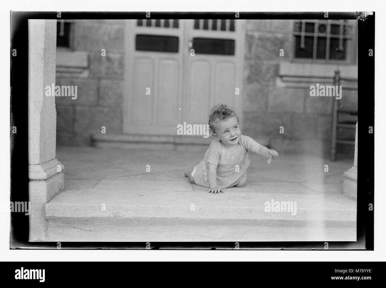 A photograph of a baby, likely in the early 20th century. The image ...