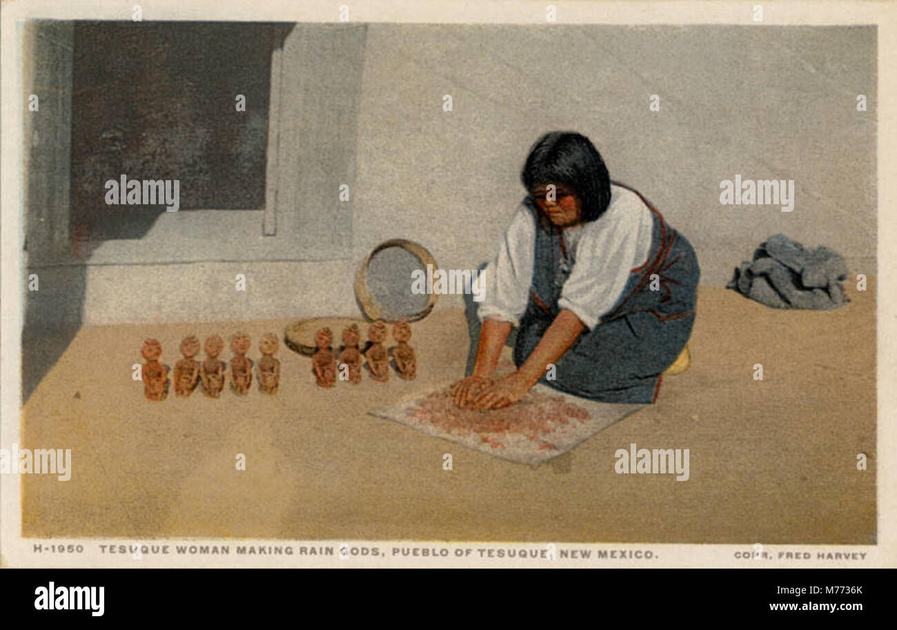 A woman from the Pueblo of Tesuque in New Mexico creates rain gods, a traditional craft, as part of the Fred Harvey series. This highlights Native American artistry and cultural heritage. Stock Photo