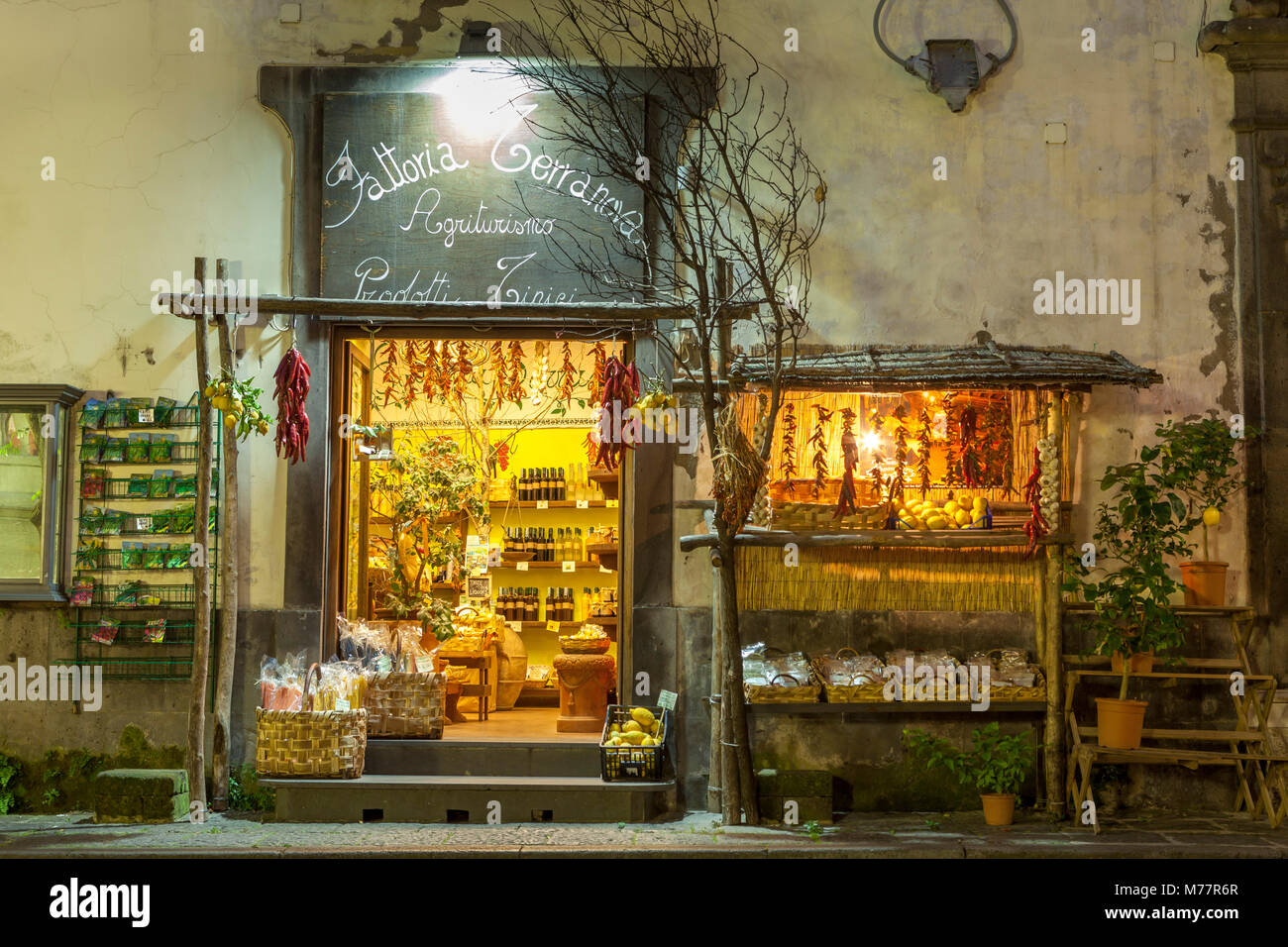 Shop lit up selling produce at night in the back streets of Sorrento, Campania, Italy, Europe Stock Photo