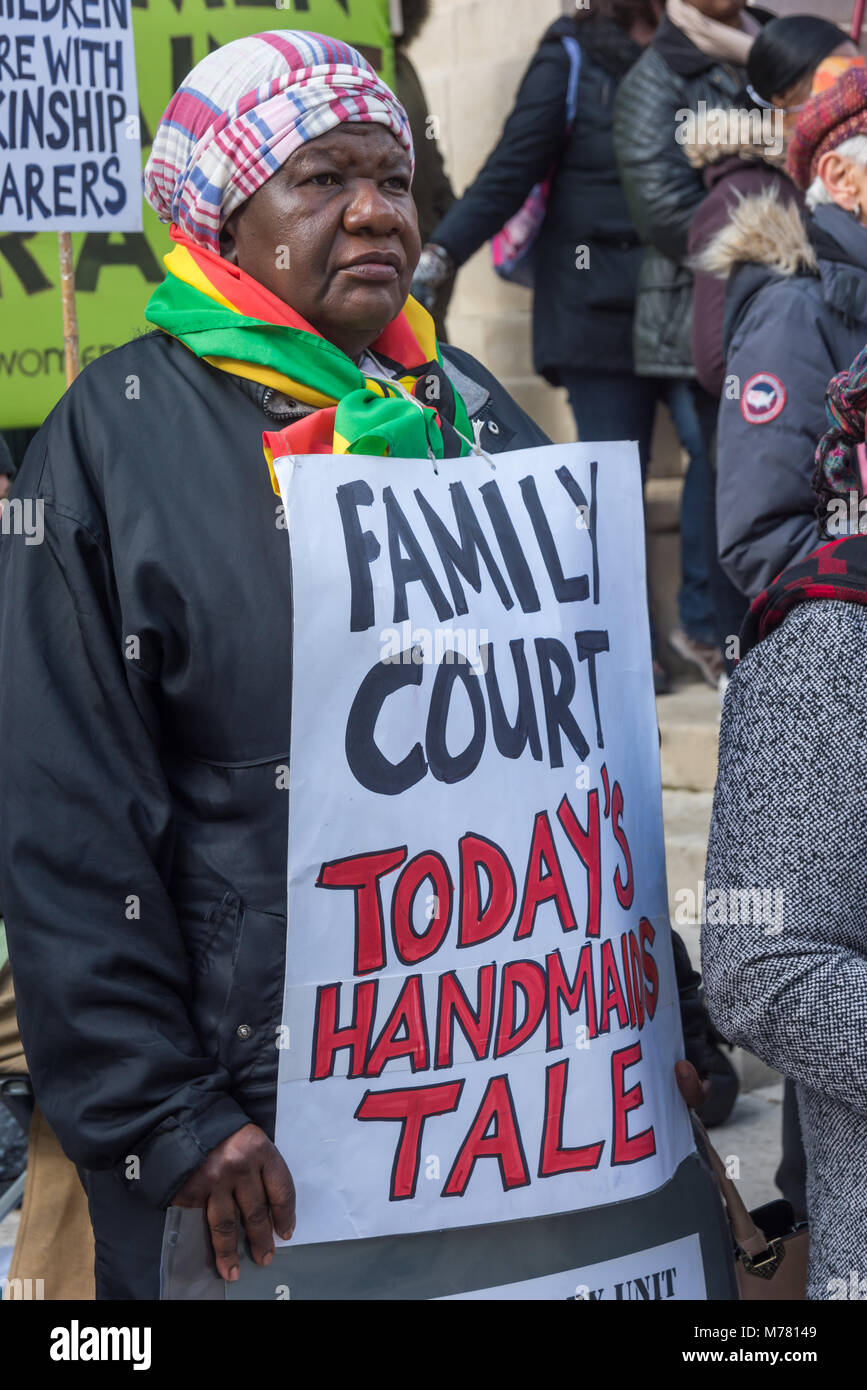 London, UK. 8th March 2018. A woman holds a poster 'Family Court - Today's Handmaids Tale' at the Global Women's Strike mock trial of the Family Courts in an International Women’s Day protest in front of Parliament. Speakers included mothers who have had children unjustly removed and others who read out shocking comments made in court by judges. portion Credit: Peter Marshall/Alamy Live News Stock Photo