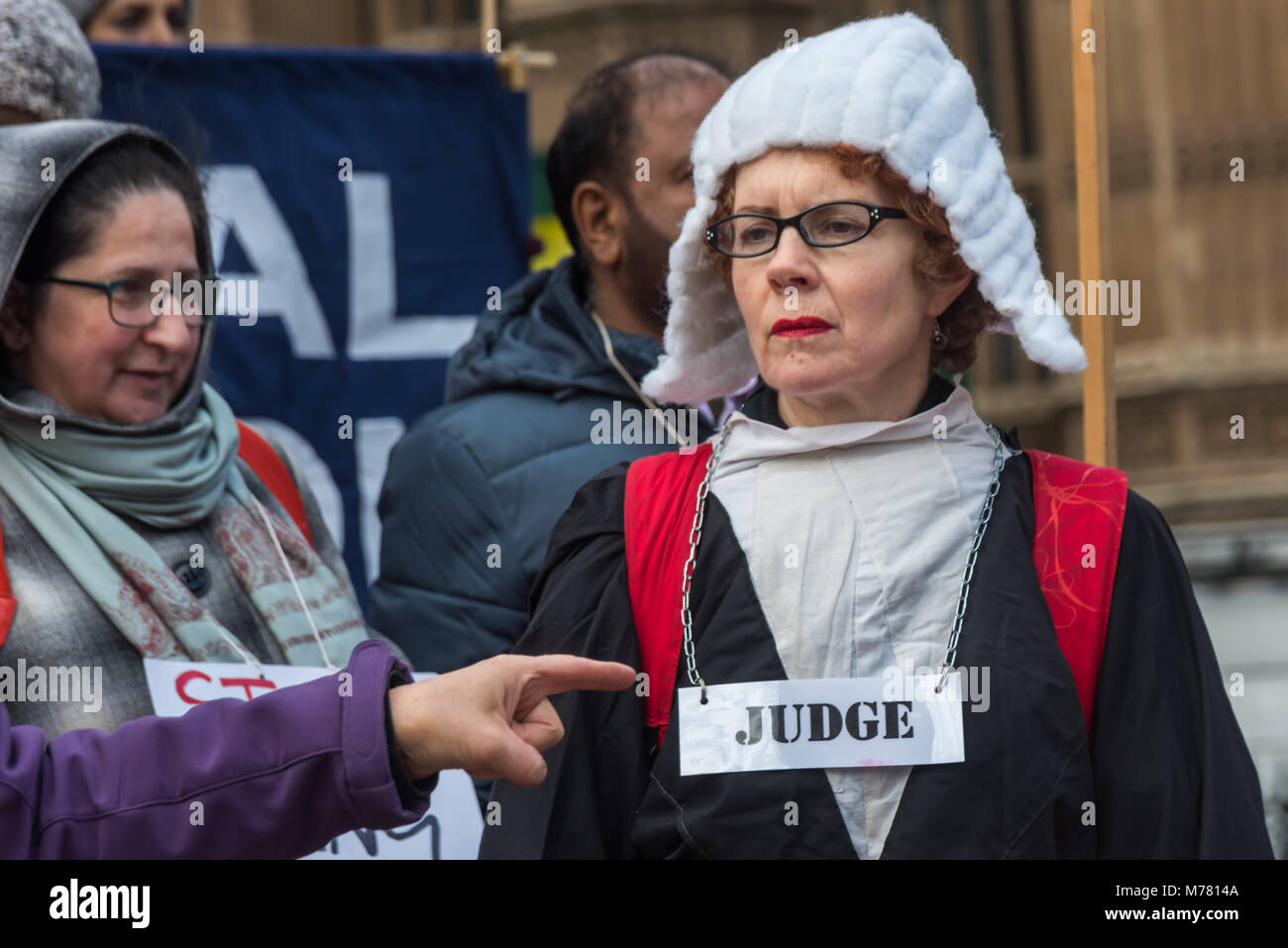 London, UK. 8th March 2018. A pointing finger accuses a Judge at the Global Women's Strike mock trial of the Family Courts in an International Women’s Day protest in front of Parliament. Speakers included mothers who have had children unjustly removed and others who read out shocking comments made in court by judges. The UK has the highest rate of adoptions in Europe, almost all without consent of their birth family. ey say tha Credit: Peter Marshall/Alamy Live News Stock Photo