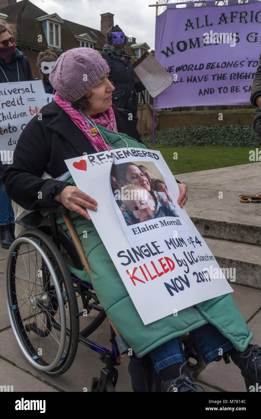 London, UK. 8th March 2018. Claire Glasman of WInvisible holds a poster about a single mum killed by Universtal Credit sanction at the Global Women's Strike mock trial of the Family Courts in an International Women’s Day protest in front of Parliament. Speakers included mothers who have had children unjustly removed and others who read out shocking comments made in court by judges. The UK has the highest rate of adoptions in Europe, almost all without consent of their birth family. In some working class areas, 50% of children are referred to social services and that families of colour, immigra Stock Photo