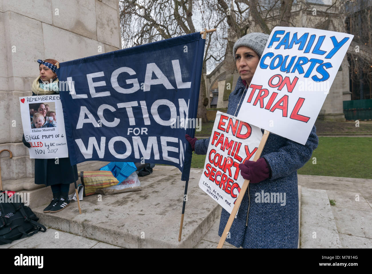 London, UK. 8th March 2018. People hold the Legal Action for Women banner and posters at the Global Women's Strike mock trial of the Family Courts in an International Women’s Day protest in front of Parliament. Speakers included mothers who have had children unjustly removed and others who read out shocking comments made in court by judges. portionately Credit: Peter Marshall/Alamy Live News Stock Photo