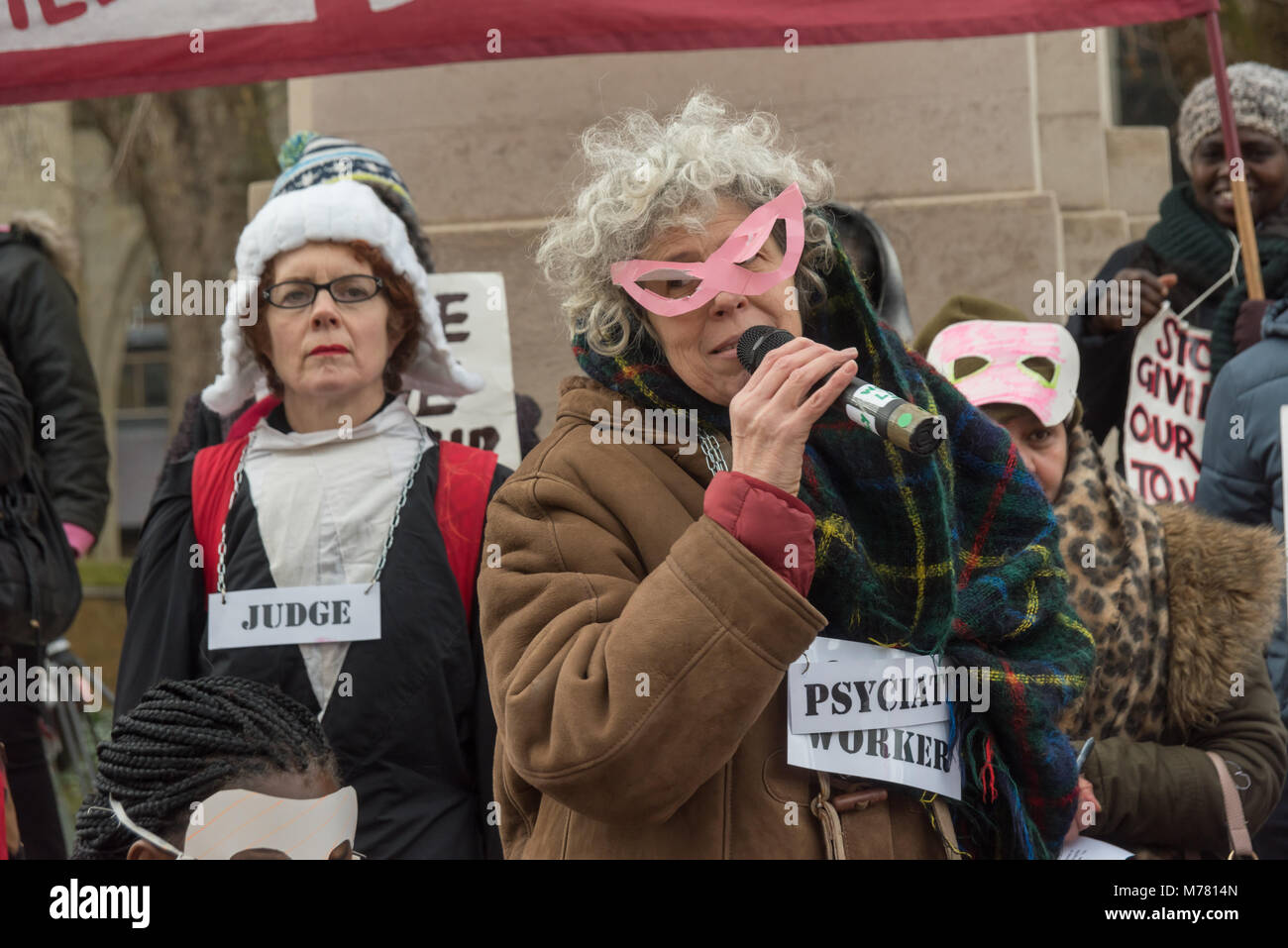 London, UK. 8th March 2018. A psychiatric social worker gives evidence of why the break up families at the Global Women's Strike mock trial of the Family Courts in an International Women’s Day protest in front of Parliament. Speakers included mothers who have had children unjustly removed and others who read out shocking comments made in court by judges. The UK has the highest rate of adoptions in Europe, almost all without consent of their birth family. In some working class areas, 50% of children are referred to social services and that families of colour, immigrant and disabled are all disp Stock Photo